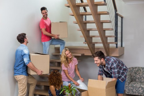 Removal workers coordinating a safe carry through a home or corridor