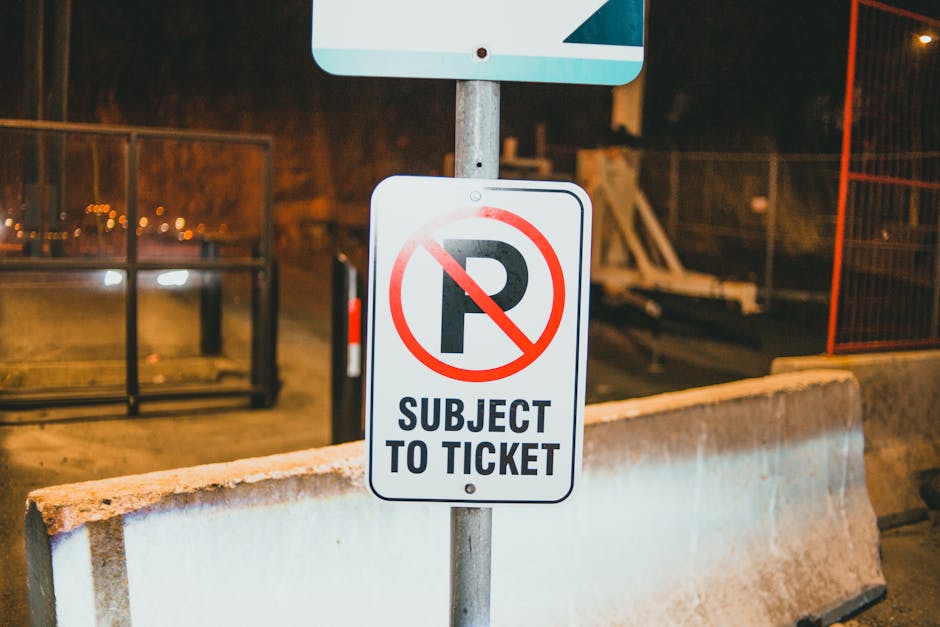 A blue and white parking sign indicating designated parking for disabled individuals, mounted on a metal post attached to a dark grey textured wall. The sign features a large white letter 'P' and a wh
